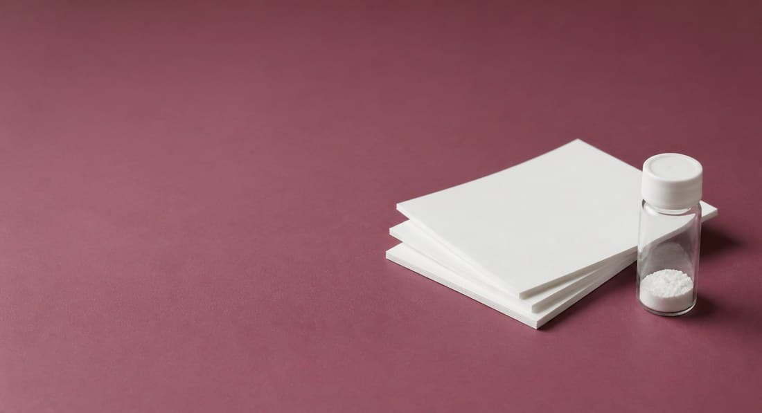 Papers and vials on a burgundy background